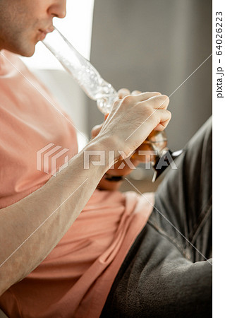 young man heats bong with a lighter 64026223