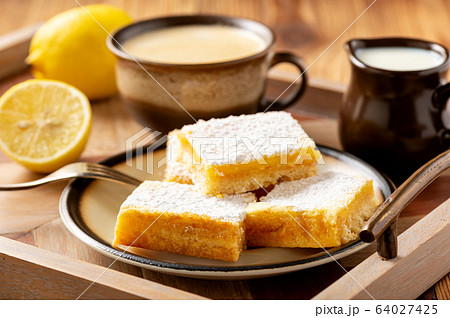 Homemade lemon bars with shortbread crust, on wooden background. Homemade lemon bars with shortbread crust, on wooden background. 64027425