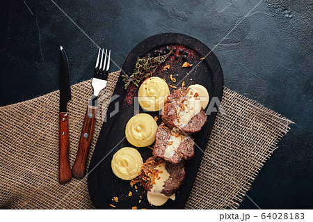 Grilled pork chops with mashed potatoes. On a dark wooden background, rustic style. Food photo. 64028183