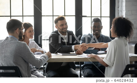 Successful businessman in suit shaking hand of african american businesswoman. 64028432