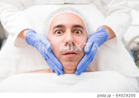 Man having face massage in beauty salon close up 64029200