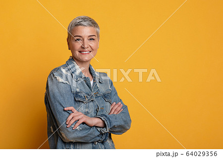 Beautiful aged woman in stylish clothes posing with folded arms 64029356