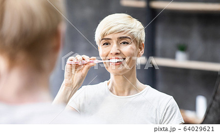 Smiling Lady Cleaning Teeth With Toothbrush In Bathroom, Panorama Smiling Lady Cleaning Teeth With Toothbrush In Bathroom, Panorama 64029621