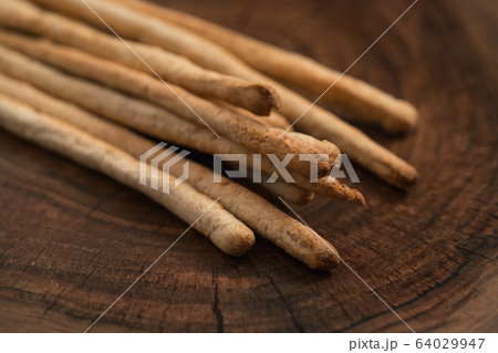 Traditional italian snack - grissini on walnut surface 64029947