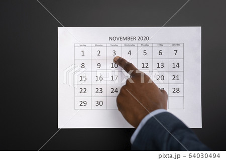 African man showing with finger on calendar date 64030494