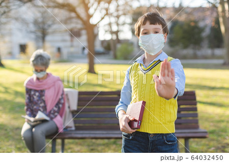 Boy giving stop sign asking for social distancing Boy giving stop sign asking for social distancing 64032450
