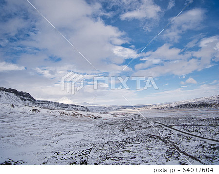 Road in Iceland through the snowy lava field Road in Iceland through the snowy lava field 64032604