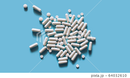 White medical pills on blue background.  64032610