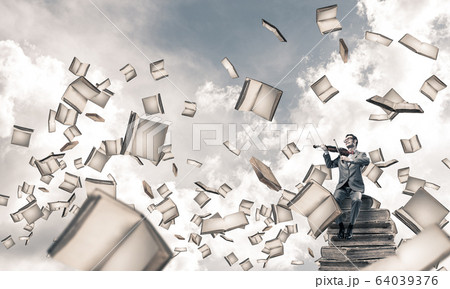 Handsome violinist sitting on book and play his melody Handsome violinist sitting on book and play his melody 64039376