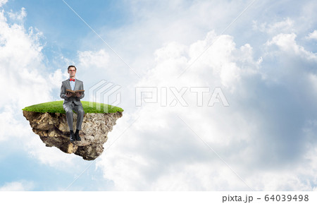 Young businessman or student floating in sky and studying the science Young businessman or student floating in sky and studying the science 64039498