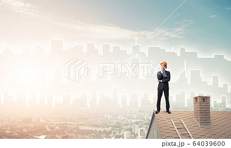 Engineer man standing on roof and looking away. Mixed media Engineer man standing on roof and looking away. Mixed media 64039600