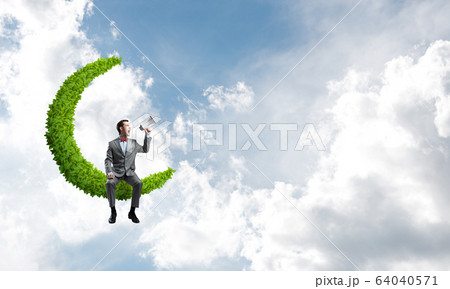 Businessman or manager in blue day sky announcing something in loudspeaker Businessman or manager in blue day sky announcing something in loudspeaker 64040571