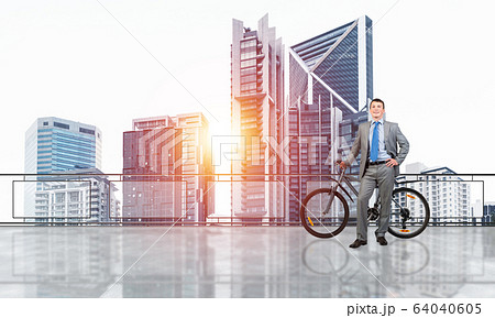 Happy man standing on balcony with bike 64040605