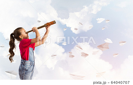 Concept of careless happy childhood with girl looking in spyglass 64040707