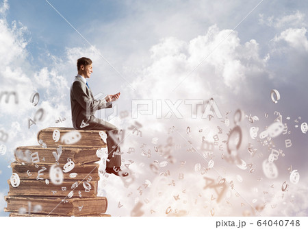 Businessman or student on book and symbols flying around Businessman or student on book and symbols flying around 64040748