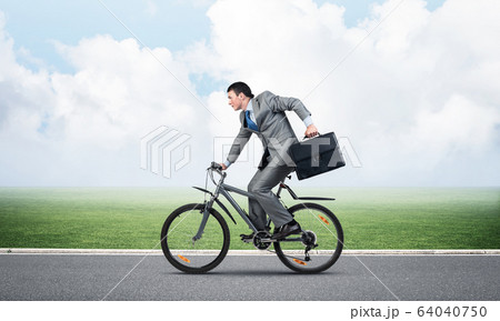 Young man riding bicycle on highway Young man riding bicycle on highway 64040750