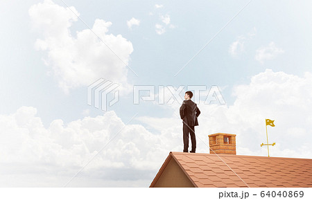 Mister boss on brick roof with arms akimbo. Mixed media Mister boss on brick roof with arms akimbo. Mixed media 64040869