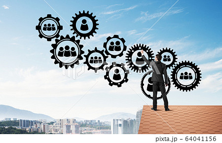 Businessman on house roof presenting teamwork and connection concept. Mixed media Businessman on house roof presenting teamwork and connection concept. Mixed media 64041156