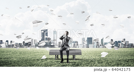 Young man in summer park on bench do not want to see anything 64042175