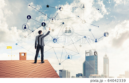 Businessman on house roof presenting networking and connection c 64042339