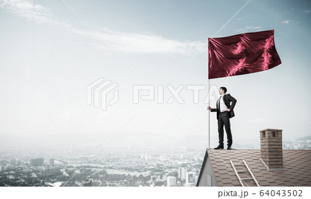 Young businessman with flag presenting concept of leadership. Mi 64043502