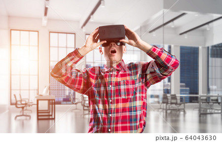 Concept of modern entertaining technologies with man wearing virtual reality mask Concept of modern entertaining technologies with man wearing virtual reality mask 64043630