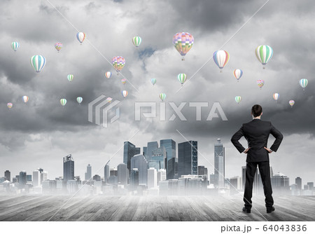 Motivation and inspiration concept with modern cityscape and businessman observing it Motivation and inspiration concept with modern cityscape and businessman observing it 64043836