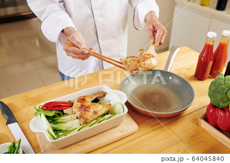 Man cooking chicken with vegetables 64045840
