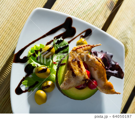Delicious fried legs of quail with balsamic pasta, avocado and greens 64050197