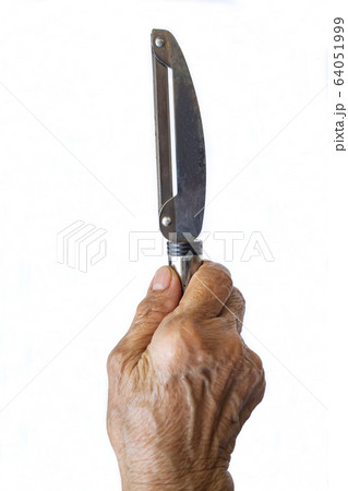 Senior woman's right hand holding Stainless peeler on white background, Close up shot, Selective focus, Kitchen utensils concept 64051999