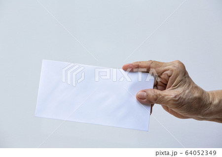 Senior woman's right hand holding white envelope or bride isolated on white background, Close up and macro shot, Business concept 64052349