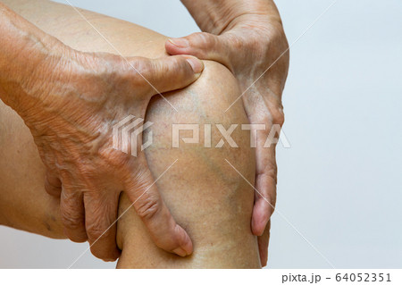 Senior woman suffering from right knee pain, Massaging by her hand in white background, Close up & Macro shot, Asian body skin part, Healthcare, About Massage concept 64052351