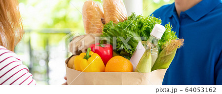Grocery delivery man delivering food to a woman at home 64053162