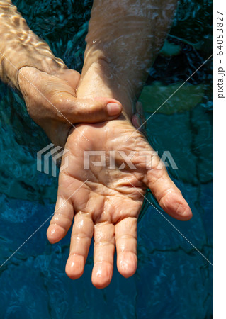 Senior woman's hands washing her hands in step 2 in bokeh blue pool  background, Close up & Macro shot, Selective focus, Prevention from covid19, Bacteria, healthcare concept, 7 step wash hand 64053827