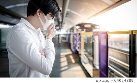Asian man wearing mask at skytrain station Asian man wearing mask at skytrain station 64054889