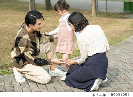 怪我をした女の子を心配する親 怪我をした女の子を心配する親 64055092