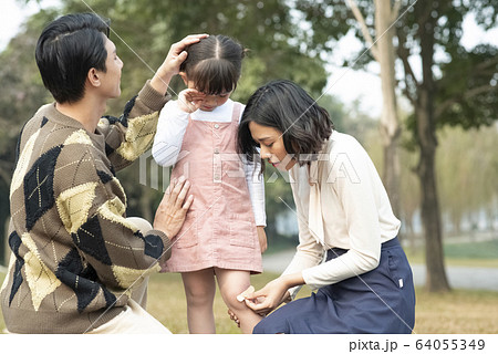 怪我をした女の子を心配する親 64055349
