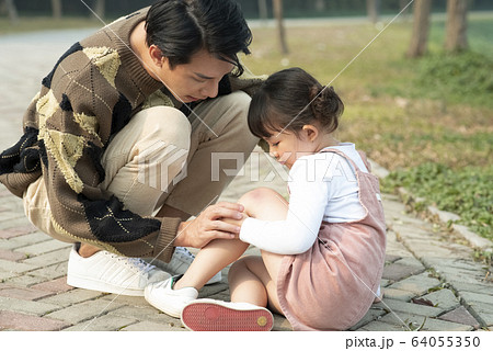 怪我をした女の子を心配する父親 64055350