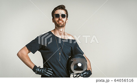 Motorbiker Posing In Studio, Isolated On Grey 64056516