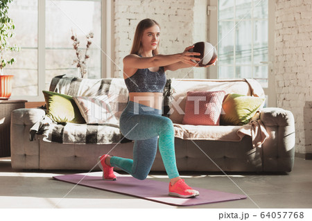 Young woman teaching at home online courses of fitness, aerobic, sporty lifestyle while being quarantine Young woman teaching at home online courses of fitness, aerobic, sporty lifestyle while being quarantine 64057768