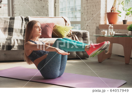 Young woman teaching at home online courses of fitness, aerobic, sporty lifestyle while being quarantine Young woman teaching at home online courses of fitness, aerobic, sporty lifestyle while being quarantine 64057949