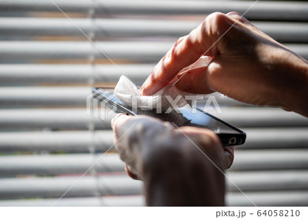 woman hands cleaning smartphone  sanitizing  64058210