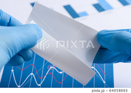 Scientist show white semi transparent layer of novel flexible material in laboratory 64058693