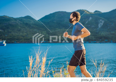 Runner wearing medical mask, Coronavirus pandemic Covid-19. Sport, Active life in quarantine Runner wearing medical mask, Coronavirus pandemic Covid-19. Sport, Active life in quarantine 64059235