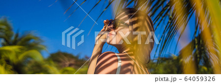 Young woman with the shadow of the palm leaf on her back. Relaxing on the seaside BANNER, LONG Young woman with the shadow of the palm leaf on her back. Relaxing on the seaside BANNER, LONG 64059326
