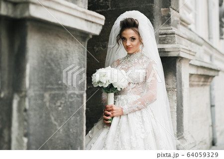 Portrait of stunning bride with long hair posing with great bouquet Portrait of stunning bride with long hair posing with great bouquet 64059329
