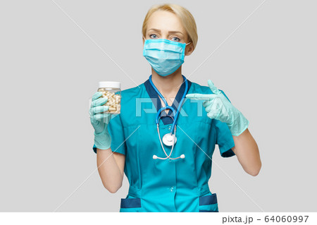 medical doctor nurse woman wearing protective mask and rubber or latex gloves - holding pills medical doctor nurse woman wearing protective mask and rubber or latex gloves - holding pills 64060997