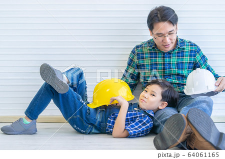 Builder father is Sitting next to his son for 64061165