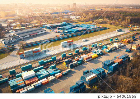 Aerial view of container loading and unloading at sunset. Top view of containers Aerial view of container loading and unloading at sunset. Top view of containers 64061968