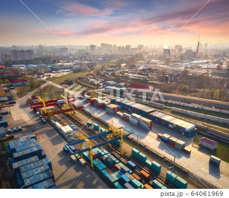 Aerial view of container loading and unloading at sunset. Top view of containers Aerial view of container loading and unloading at sunset. Top view of containers 64061969